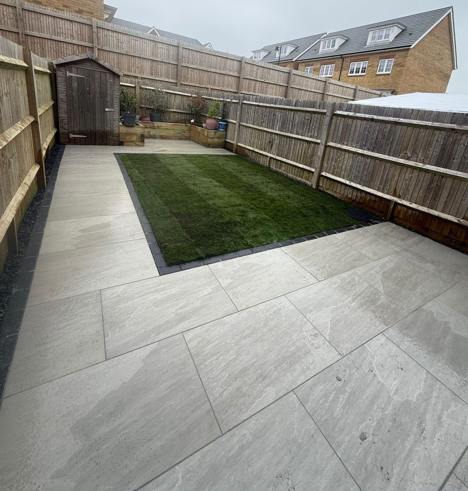 New porcelain patio and fresh lawn after landscaping