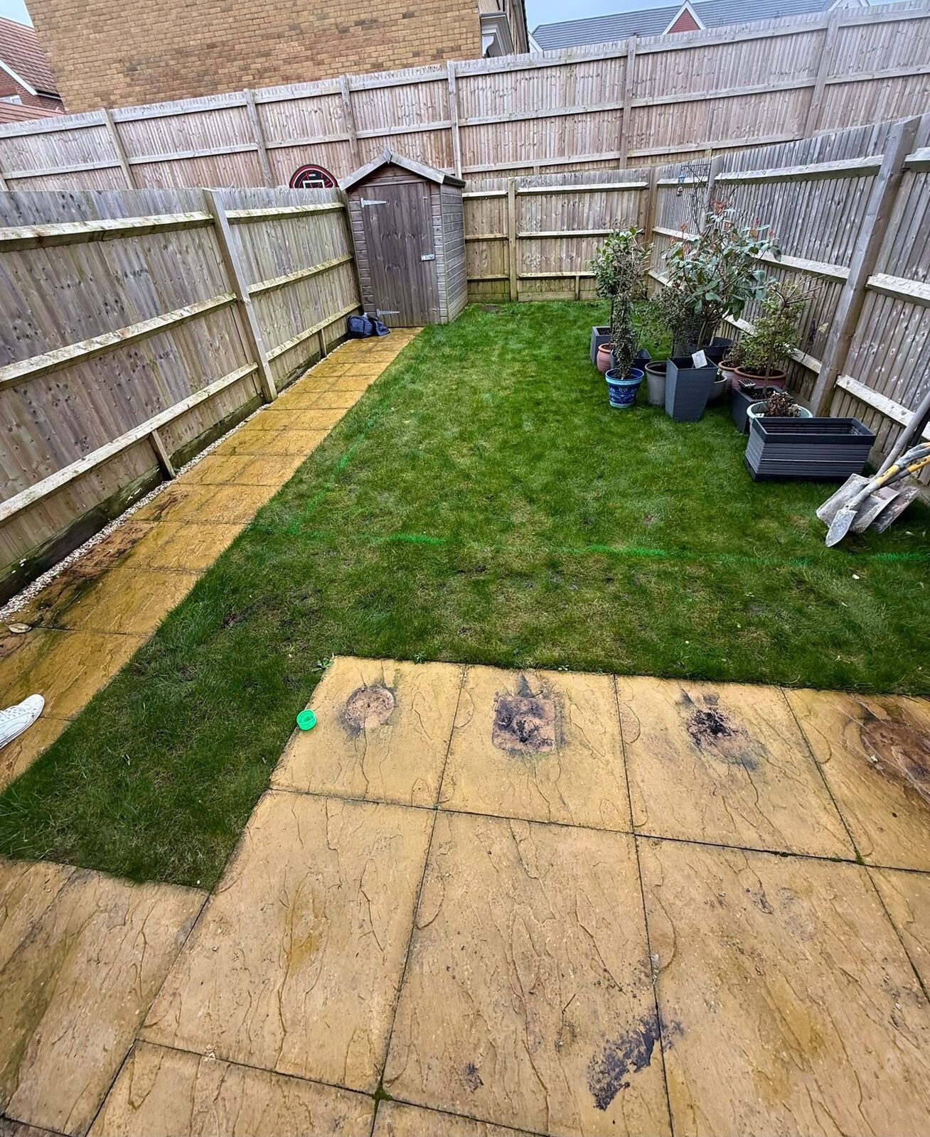 Tired garden with worn paving before landscaping