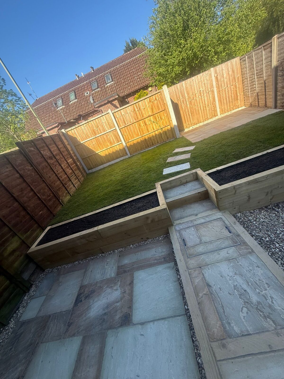 Finished garden with sandstone patio, sleeper raised beds and new lawn