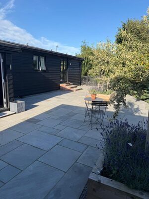 Sandstone patio with lavender planters by A Sterling Landscapes