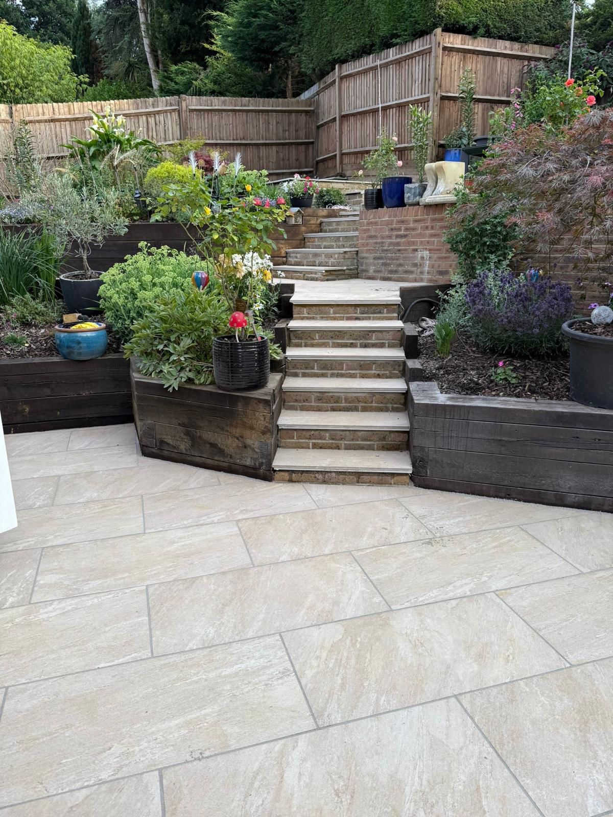 Porcelain patio with stepped planters and natural stone